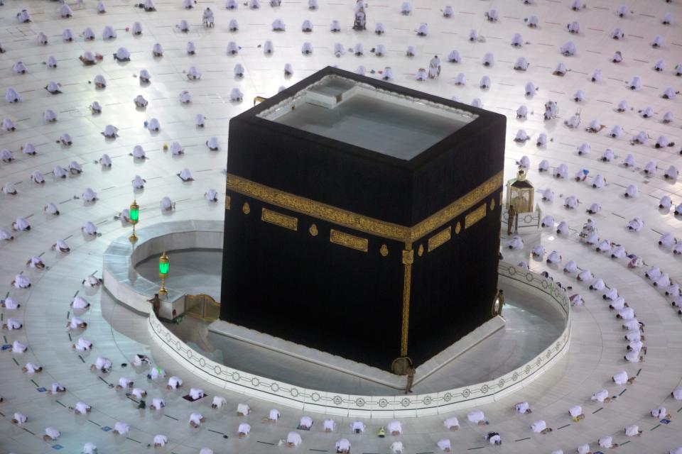 Muslims pray during the first dawn prayers of the Islamic holy month of Ramadan, around the Kaaba, the cubic building at the Grand Mosque, as they keep social distancing to help curb the spread of the coronavirus, in the Muslim holy city of Mecca, Saudi Arabia, on April 13, 2021.