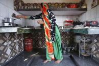 Geeta Nagar, a housewife, makes tea on a stove using a Liquefied Petroleum Gas (LPG) cylinder in her kitchen at Dujana village in Noida, on the outskirts of New Delhi October 7, 2015. REUTERS/Anindito Mukherjee