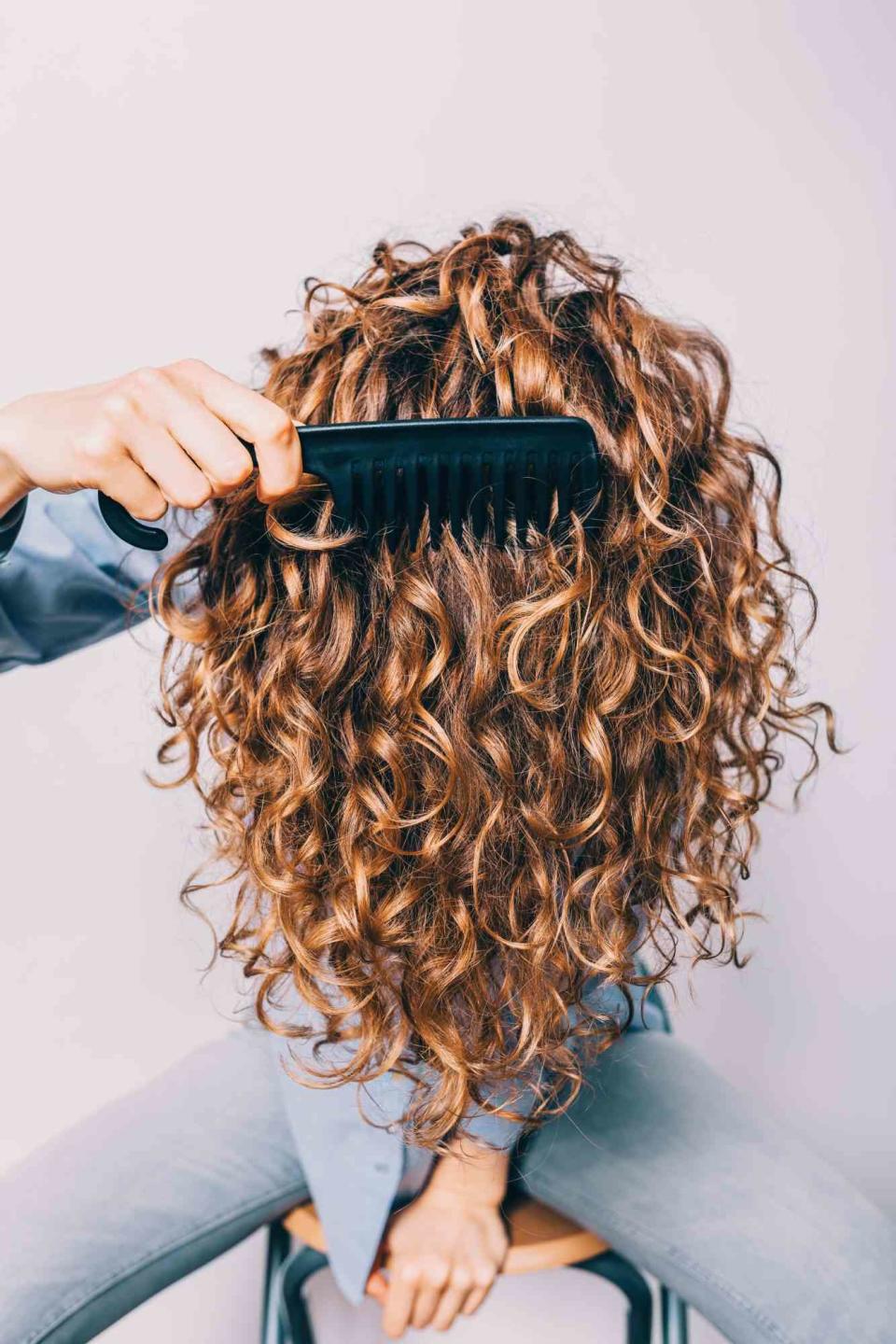 woman combing curly hair