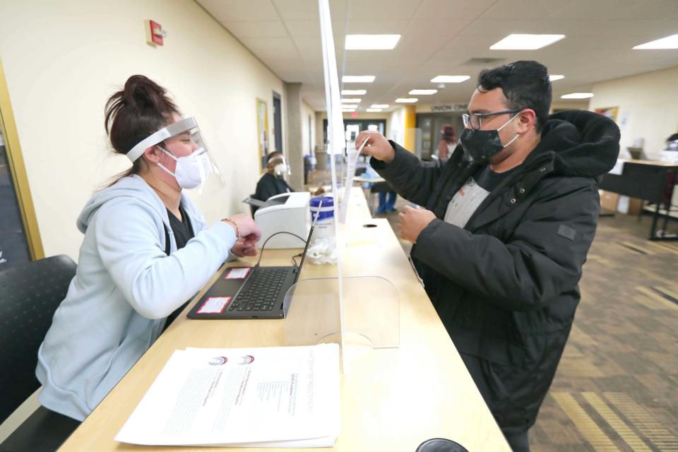 A staff member helps a patient get registered for a rapid-result COVID-19 testing at the University of Wisconsin-Milwaukee student union on campus in Milwaukee in November 2020.