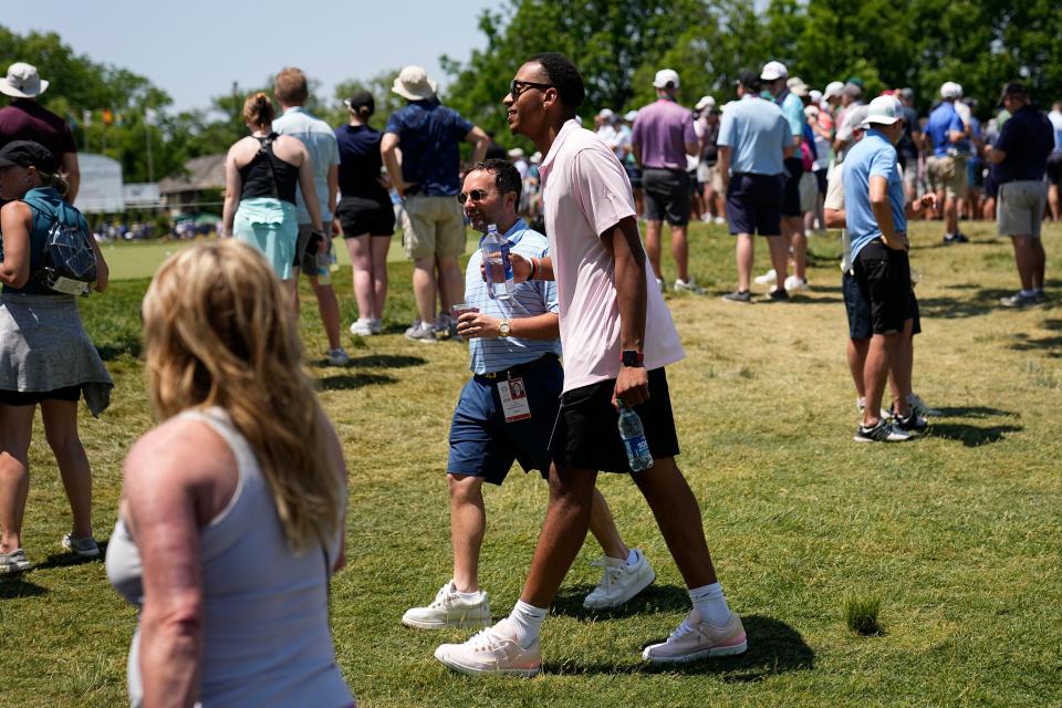 June 1, 2023; Dublin, Ohio, USA;  Ohio State basketball player Zed Key walks with Brian Schottenstein past the putting green during the opening round of the Memorial Tournament at Muirfield Village Golf Club. 
