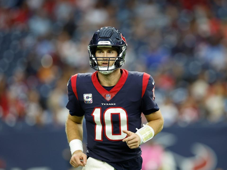 Davis Mills stands on the field during a Texans game.