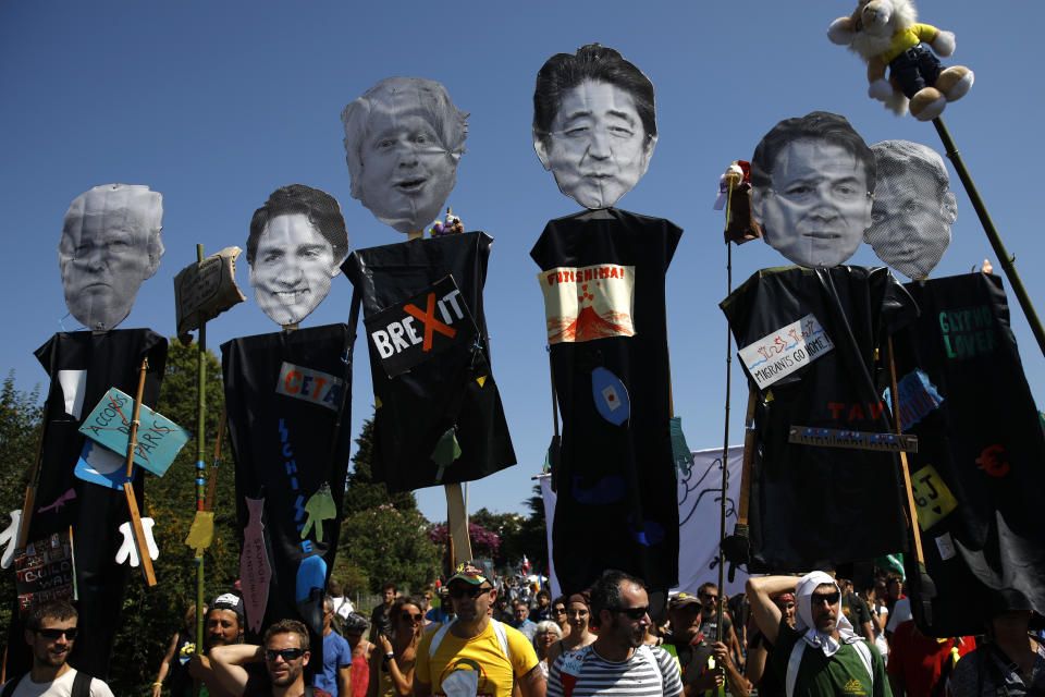 Anti-G-7 activists carry pictures of the G-7 leaders during a protest in Hendaye, France, Saturday, Aug. 24, 2019. World leaders and protesters are converging on the southern French resort town of Biarritz for the G-7 summit. President Donald Trump will join host French President Emmanuel Macron and the leaders of Britain, Germany, Japan, Canada and Italy for the annual summit in the nearby resort town of Biarritz. (AP Photo/Emilio Morenatti)