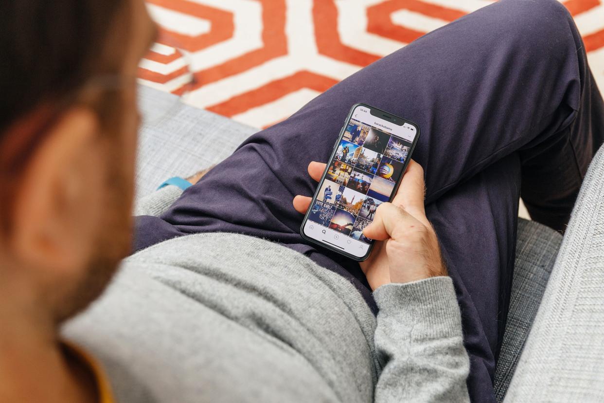 man holding Barack Obama Instagram photos on the new Apple iPhone
