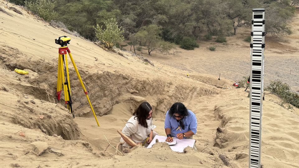 A team of archeologists work on what appear to be parts of a 4,000-year-old ceremonial temple buried in a sand dune in northern Peru. - Peru's Pontifical Catholic University/Reuters