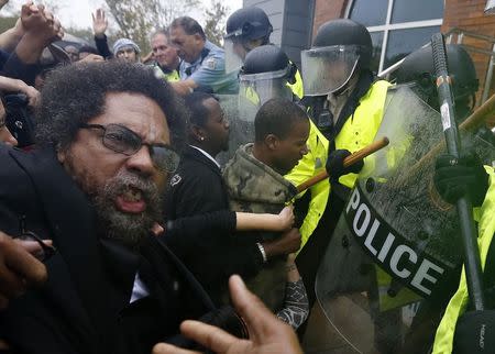 Activist Cornel West is knocked over during a scuffle with police during a protest at the Ferguson Police Department in Ferguson, Missouri, October 13, 2014. REUTERS/Jim Young