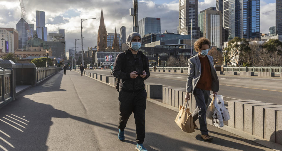 Pedestrians walk away from the central business district as lockdown due to the continuing spread of the coronavirus starts in Melbourne.