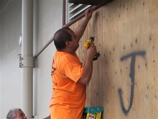 Giuseppe Manone boards up the windows of a store in Hilo, Hawaii as Hurricane Madeline approached the Big Island on Wednesday, Aug. 31, 2016. Drier air and strong upper atmosphere winds are weakening Hurricane Madeline as it approaches Hawaii. (AP Photo/Audrey McAvoy)