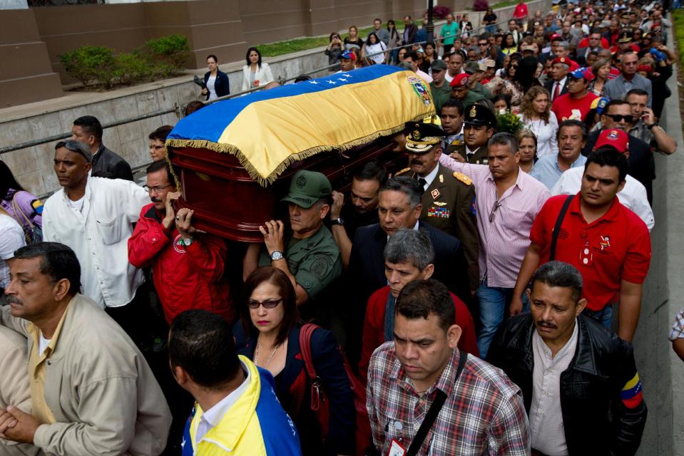 Army mates of former Venezuelan Intelligence Chief Eliezer Otaiza carry his body outside the National Assembly during a funeral procession in Caracas, Venezuela, Wednesday, April 30, 2014. Otaiza's body was dumped on the edge of Caracas Saturday after his vehicle was intercepted by a group of armed men. No motive has been established for the crime. As a young army officer, he backed Hugo Chavez's failed 1992 coup attempt and was responsible for his personal security when he was elected president in 1998. (AP Photo/Fernando Llano)