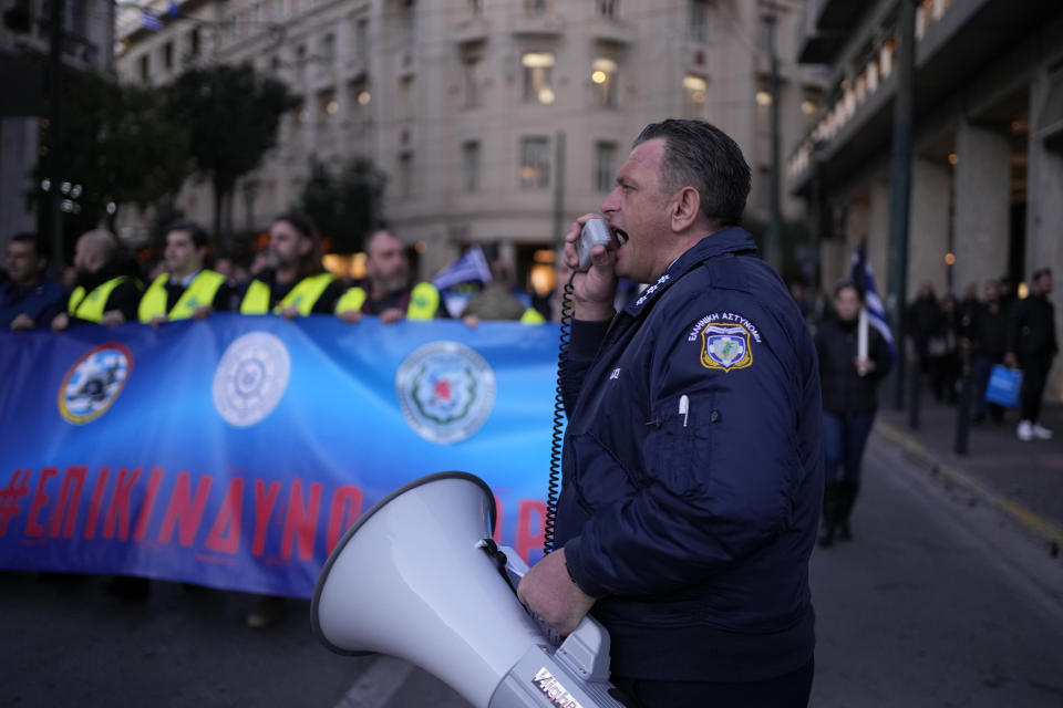 A policeman shouts slogans during a protest by uniformed officers in Athens, Greece, Monday, Dec. 18, 2023. About 1,500 people took part in the rally, organized by police, firefighters and coast guard unions in response to the non-legalization of their profession as hazardous. (AP Photo/Thanassis Stavrakis)