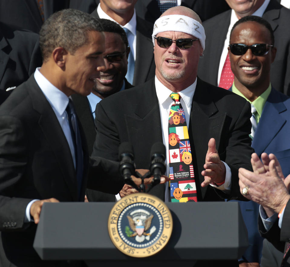 FILE - In this Oct. 7, 2011 file photo, President Barack Obama, left, looks towards quarterback Jim McMahon, center, wearing headband, as he honors the 1985 Super Bowl XX Champions Chicago Bears football team during a ceremony on the South Lawn of the White House in Washington. A U.S. appeals court has revived a lawsuit against the NFL by former players, including McMahon, who claim the league illegally plied them with powerful prescription painkillers to keep them on the field. (AP Photo/Pablo Martinez Monsivais, File)