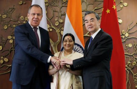 Russian Foreign Minister Sergei Lavrov (L) Indian Foreign Minister Sushma Swaraj  (C) and Chinese Foreign Minister Wang Yi shake hands before the start of their meeting in New Delhi, India, December 11, 2017. REUTERS/Adnan Abidi