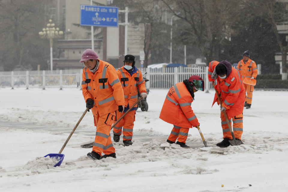 Trabajadores retiran el hielo y la nieve durante una nevada en la ciudad de Huaibei, en la provincia de Anhui, en el centro de China, el 21 de febrero de 2024. (Chinatopix vía AP)