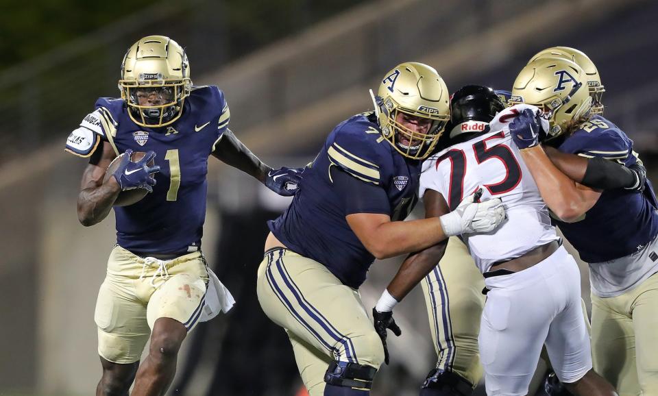 Akron Zips running back Cam Wiley (1) rushes for yardage as Akron Zips offensive lineman Max Banes (71) and Akron Zips tight end Tristian Brank (25) block during the second half of an NCAA football game, Thursday, Sept. 1, 2022, in Akron, Ohio.