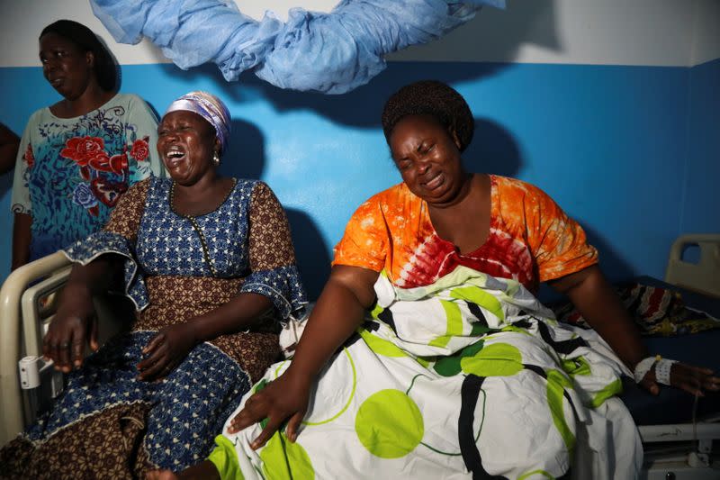 Residents N. Guessa Sidonie and Koua Bosson Mariette react after having lost a relative and their property during post electoral inter-community clashes on Monday and Tuesday, in M'Batto