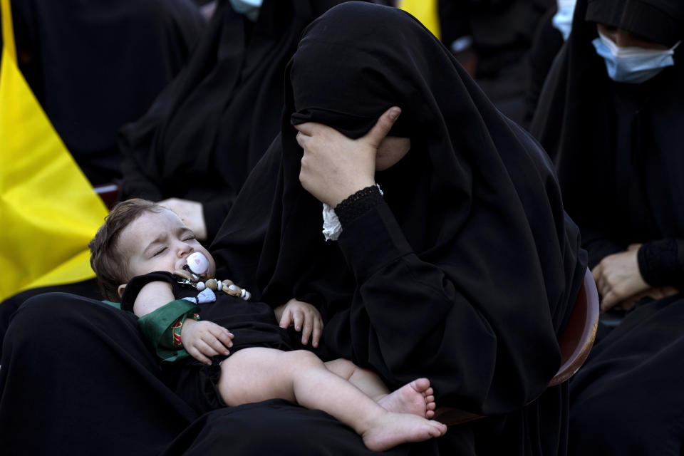 A Lebanese Shiite supporter of Hezbollah listens to the story of Imam Hussein, during activities marking the holy day of Ashoura, in southern Beirut, Lebanon, Thursday, Aug. 19, 2021. The leader of the militant Hezbollah group Sayyed Hassan Nasrallah said Thursday that the first Iranian fuel tanker will sail toward Lebanon "within hours" warning Israel and the United States not to intercept it. (AP Photo/ Hassan Ammar)