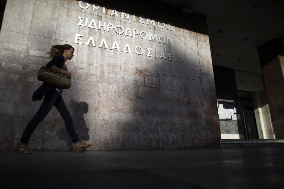 A pedestrian passes a sign of Greece's railways at the central train station of Athens during a 24-hour nationwide general strike on Thursday, Oct. 18, 2012. Labor unions in recession-hobbled Greece are holding another general strike against a new harsh austerity program, as European leaders beset by a deep debt crisis and economic stagnation gather for a summit meeting in Brussels. (AP Photo/Kostas Tsironis)