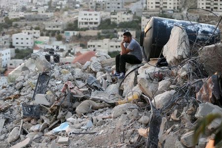 A Palestinian man sits atop the rubble of a house which was destroyed by Israeli troops during an Israeli raid in the West Bank city of Jenin September 1, 2015. REUTERS/Mohamad Torokman