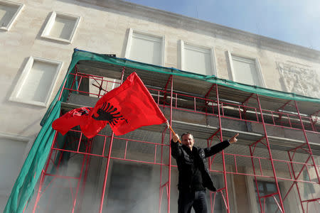 A supporter of the opposition party waves the national flag during an anti-government protest in front of Prime Minister Edi Rama's office in Tirana, Albania February 16, 2019. REUTERS/Florion Goga