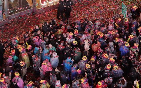 Confetti drops over the crowd as the clock strikes midnight during the New Year's celebration in Times Square  - Credit: AP