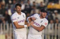 England's James Anderson, center, and Ben Stokes celebrate after the dismissal of Pakistan's Zahid Mahmood during the fifth day of the first test cricket match between Pakistan and England, in Rawalpindi, Pakistan, Monday, Dec. 5, 2022. (AP Photo/Anjum Naveed)