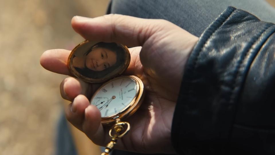 Caine holds a gold pocket watch with his daughter's photo in John Wick: Chapter 4