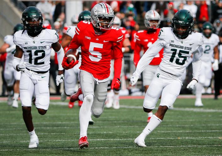 Sat., Nov. 20, 2021; Columbus, Ohio, USA; Ohio State Buckeyes wide receiver Garrett Wilson (5) runs the ball during the first quarter of a NCAA Division I football game between the Ohio State Buckeyes and the Michigan State Spartans at Ohio Stadium. Mandatory Credit: Joshua A. Bickel/Columbus Dispatch via USA TODAY Network.