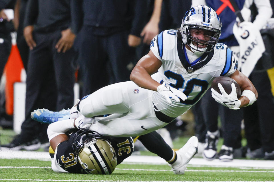 Carolina Panthers running back Chuba Hubbard is tackled by New Orleans Saints safety Jordan Howden during the first half of an NFL football game in New Orleans, Sunday, Dec. 10, 2023. (AP Photo/Butch Dill)