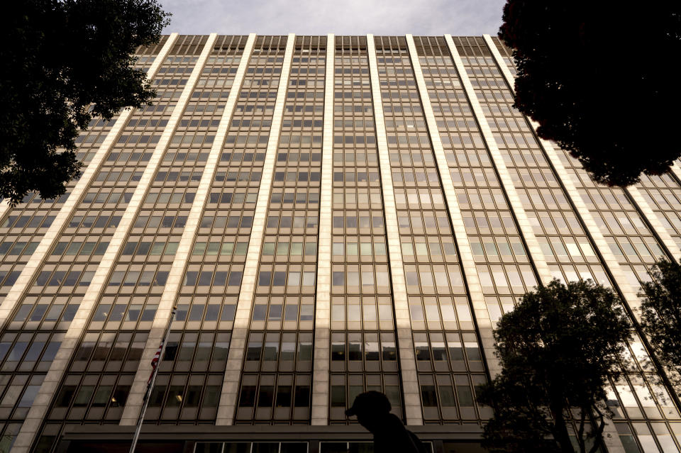 A pedestrian passes the Phillip Burton Federal Building and U.S. Courthouse where the federal trial of David DePape is underway in San Francisco on Thursday, Nov. 9, 2023. Prosecutors say DePape broke into former House Speaker Nancy Pelosi's home and bludgeoned her husband Paul Pelosi with a hammer in Oct. 2022. (AP Photo/Noah Berger)