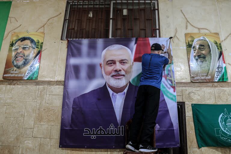 Un palestino cuelga una enorme foto de Ismail Haniyeh, el principal dirigente político de Hamas, asesinado en Teherán, en un salón del campo de refugiados palestinos de Burj al-Brajneh, mientras el movimiento se prepara para recibir las condolencias por su muerte.