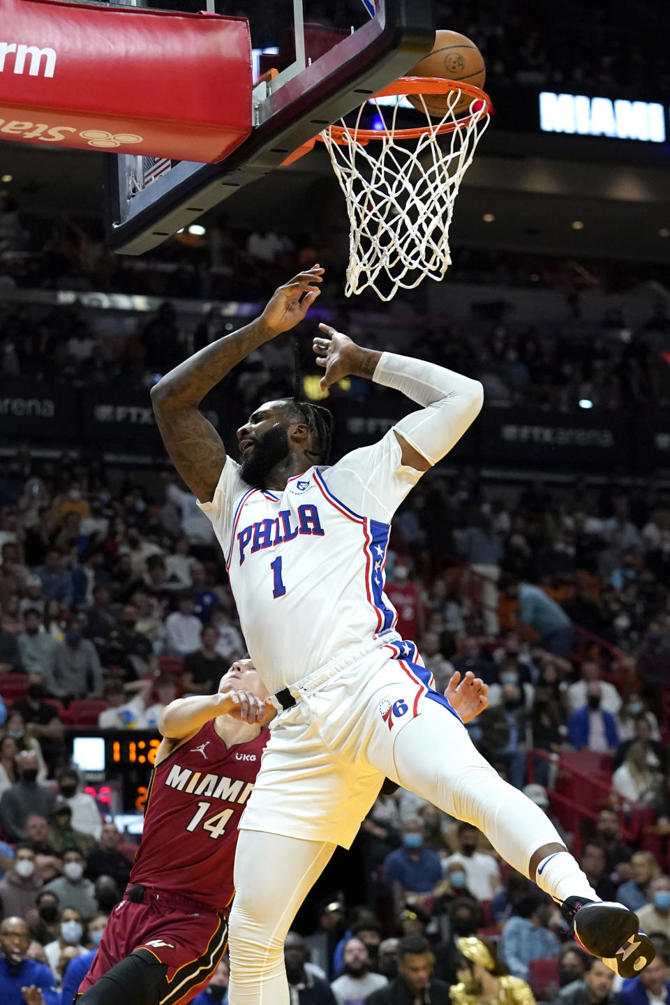 Philadelphia 76ers center Andre Drummond (1) is fouled by Miami Heat guard Tyler Herro (14) during the first half of an NBA basketball game, Saturday, Jan. 15, 2022, in Miami. (AP Photo/Lynne Sladky)