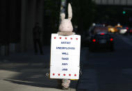 A person dressed as a bunny walks down the street with a sign in New York May 13, 2009. REUTERS/Shannon Stapleton (UNITED STATES SOCIETY IMAGES OF THE DAY)