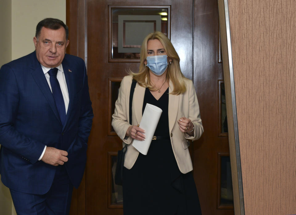 Bosnian Serb member of the tripartite Bosnian presidency Milorad Dodik, left, and President of Republika Srpska Zeljka Cvijanovic arrive at the parliament session in Banja Luka, Bosnia, Friday, Dec. 10, 2021. The Bosnian Serb parliament convened on Friday to vote on a set of steps that would weaken the war-ravaged Balkan country's central authority as their leader steps up his secession campaign despite a threat of new U.S. and other sanctions. (AP Photo/Radivoje Pavicic)