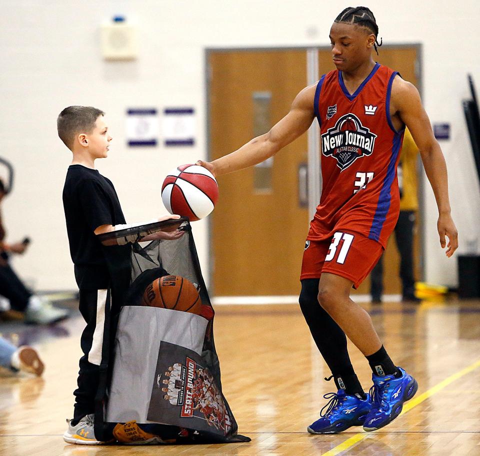 Randall Leicy gets gifts from South All-Stars' Amarr Davis (31) during the News Journal All-Star Classic Friday, March 29, 2024 at Lexington High School. TOM E. PUSKAR/MANSFIELD NEWS JOURNAL