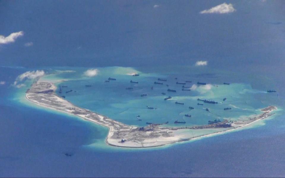  Chinese dredging vessels are purportedly seen in the waters around Mischief Reef in the disputed Spratly Islands in the South China Sea - Credit:  U.S. Navy/Handout /REUTERS