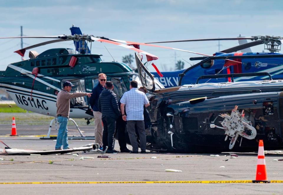 Officials inspect a crashed helicopter at Sacramento Executive Airport on Wednesday, March 15, 2023.
