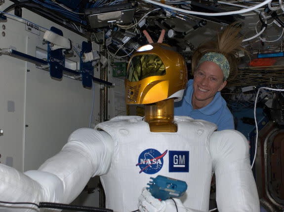 Aboard the International Space Station, astronaut Karen Nyberg indulges in a moment of levity with Robonaut 2. Image tweeted on June 28, 2013.