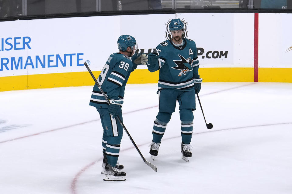 San Jose Sharks' Logan Couture (39) is congratulated by teammate Erik Karlsson (65) after scoring the winning goal against the Los Angeles Kings during overtime in a preseason NHL hockey game in San Jose, Calif., Sunday Sept. 25, 2022. (AP Photo/Tony Avelar)