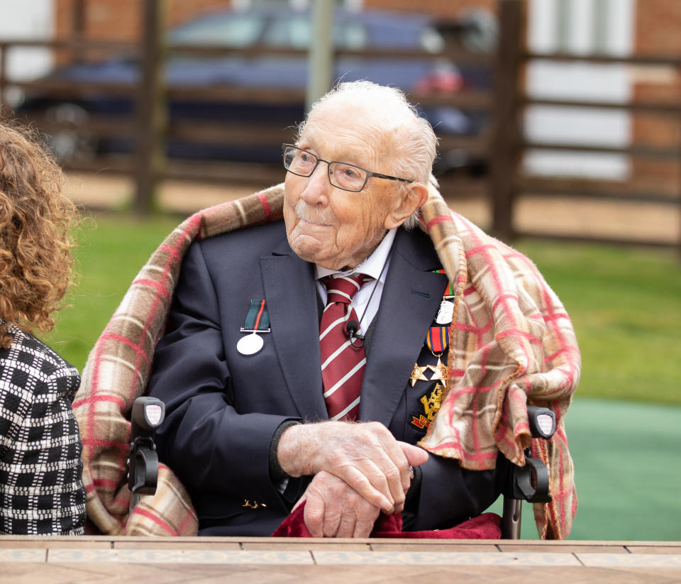 MARSTON MORETAINE, ENGLAND - In this handout image provided by Capture the Light Photography, Colonel Tom Moore and his daughter Hannah celebrate his 100th birthday, with an RAF flypast provided by a Spitfire and a Hurricane over his home on April 30, 2020 in Marston Moretaine, England. Colonel Moore, formerly a Captain, received a promotion in honour of his 100th birthday and in recognition of the funds, in excess of £29m, he raised for the NHS by walking laps of his garden. (Emma Sohl - Capture the Light Photography via Getty Images)