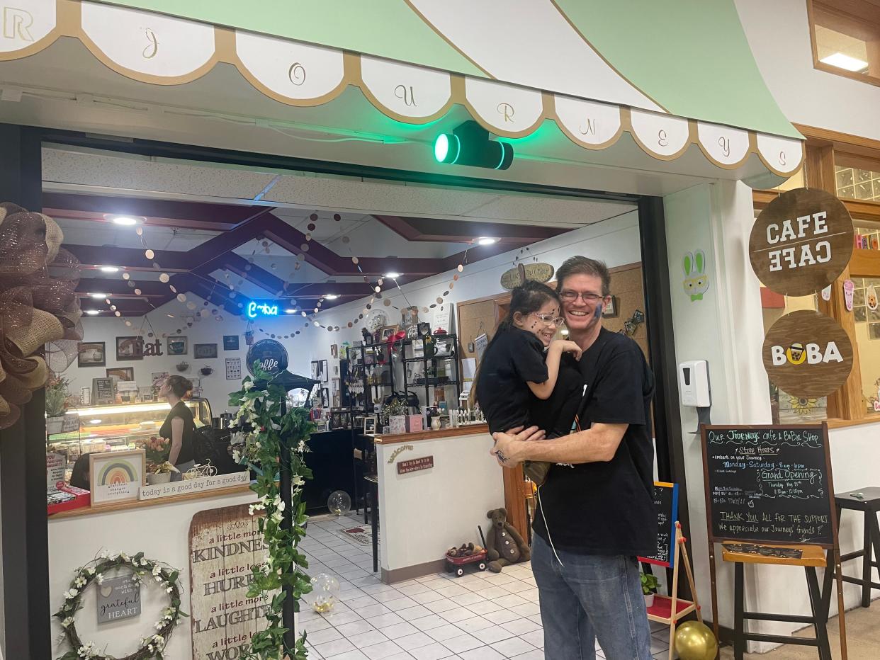 Russ Nygaard poses for a photo with his daughter, Nalani, in front of the family's new business, Our Journeys Cafe and Boba Shop, on May 25, 2023, in Freeport.