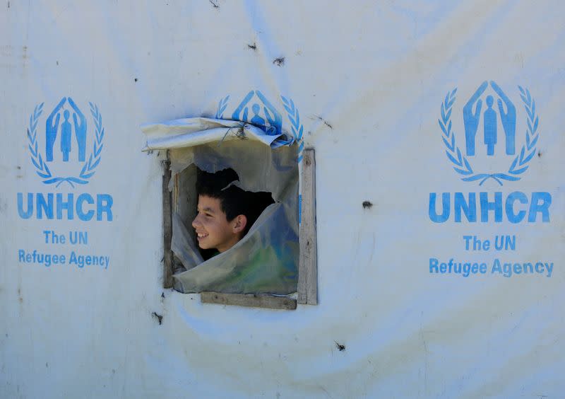 A Syrian refugee boy looks out from a tent window, as Lebanon extends a lockdown to combat the spread of the coronavirus disease (COVID-19) at a Syrian refugee camp in the Bekaa valley