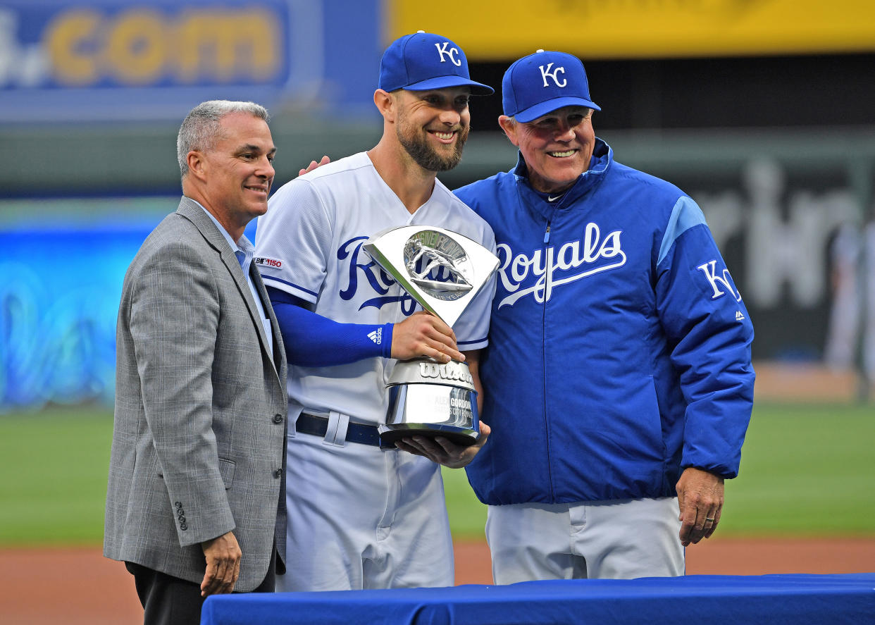 Apr 13, 2019; Kansas City, MO, USA; Kansas City Royals left fielder Alex Gordon (center) receives the Defensive Player of the Year Award from General Manager Dayton Moore (left) and manager Ned Yost (right), prior to the start of the game against the Cleveland Indians at Kauffman Stadium. Mandatory Credit: Peter G. Aiken/USA TODAY Sports