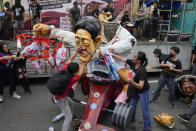 Protesters destroy an effigy of Philippine President Ferdinand Marcos Jr. during a rally as they commemorate International Human Rights Day, Saturday, Dec. 10, 2022, in Manila, Philippines. Hundreds of people marched in the Philippine capital on Saturday protesting what they said was a rising number of extrajudicial killings and other injustices under the administration of President Ferdinand Marcos Jr. (AP Photo/Aaron Favila)