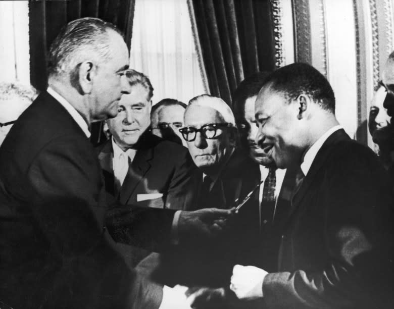 President Lyndon Johnson hands a pen to Martin Luther King Jr. during the signing of the 1965 Voting Rights Act in Washington. (Getty Images)