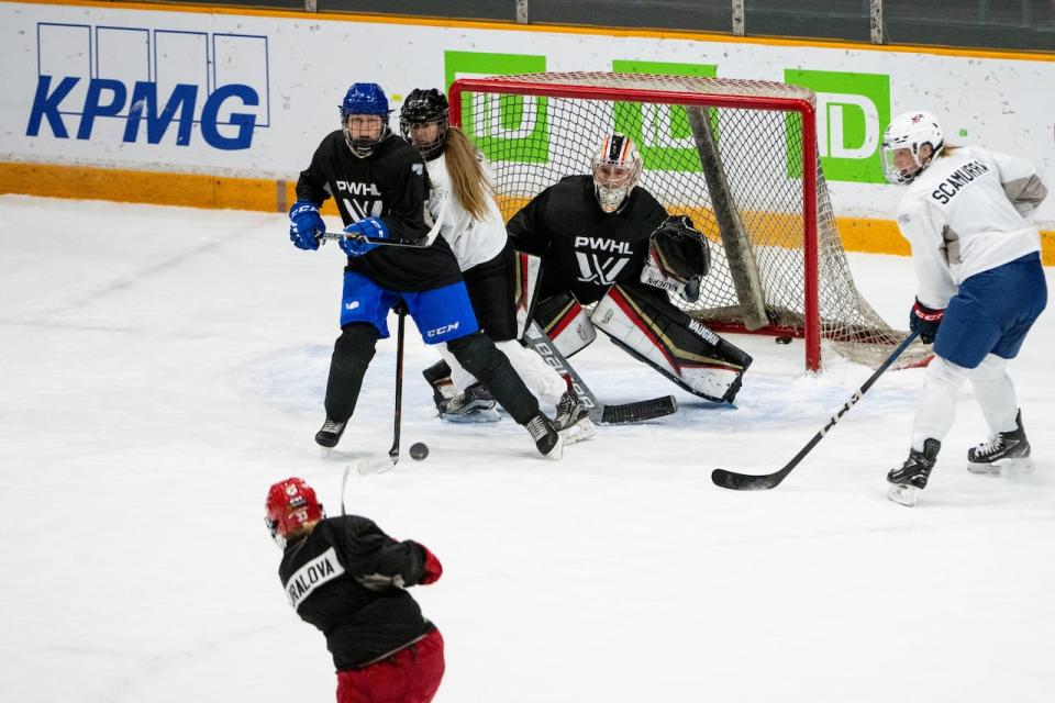 Ottawa's Aneta Tejralová unleashes a shot against goalie Sandra Abstreiter during the PWHL team's first practice on Friday.  (Spencer Colby/The Canadian Press - image credit)