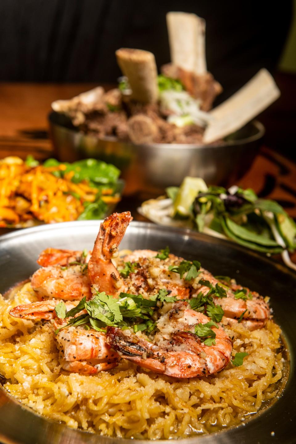 Garlic noodles with prawns, foreground, is one of the signature dishes from the PHO.