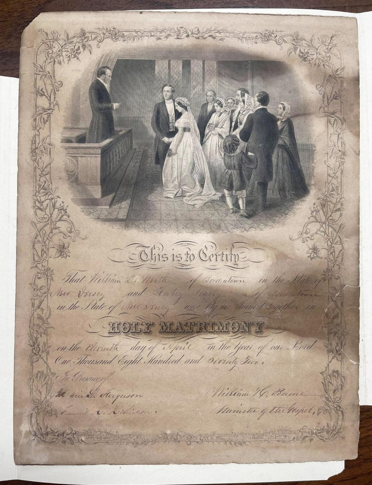 The marriage certificate of William DeWorth and Katey Havey as well as the photo that the certificate was discovered hidden in the back of.