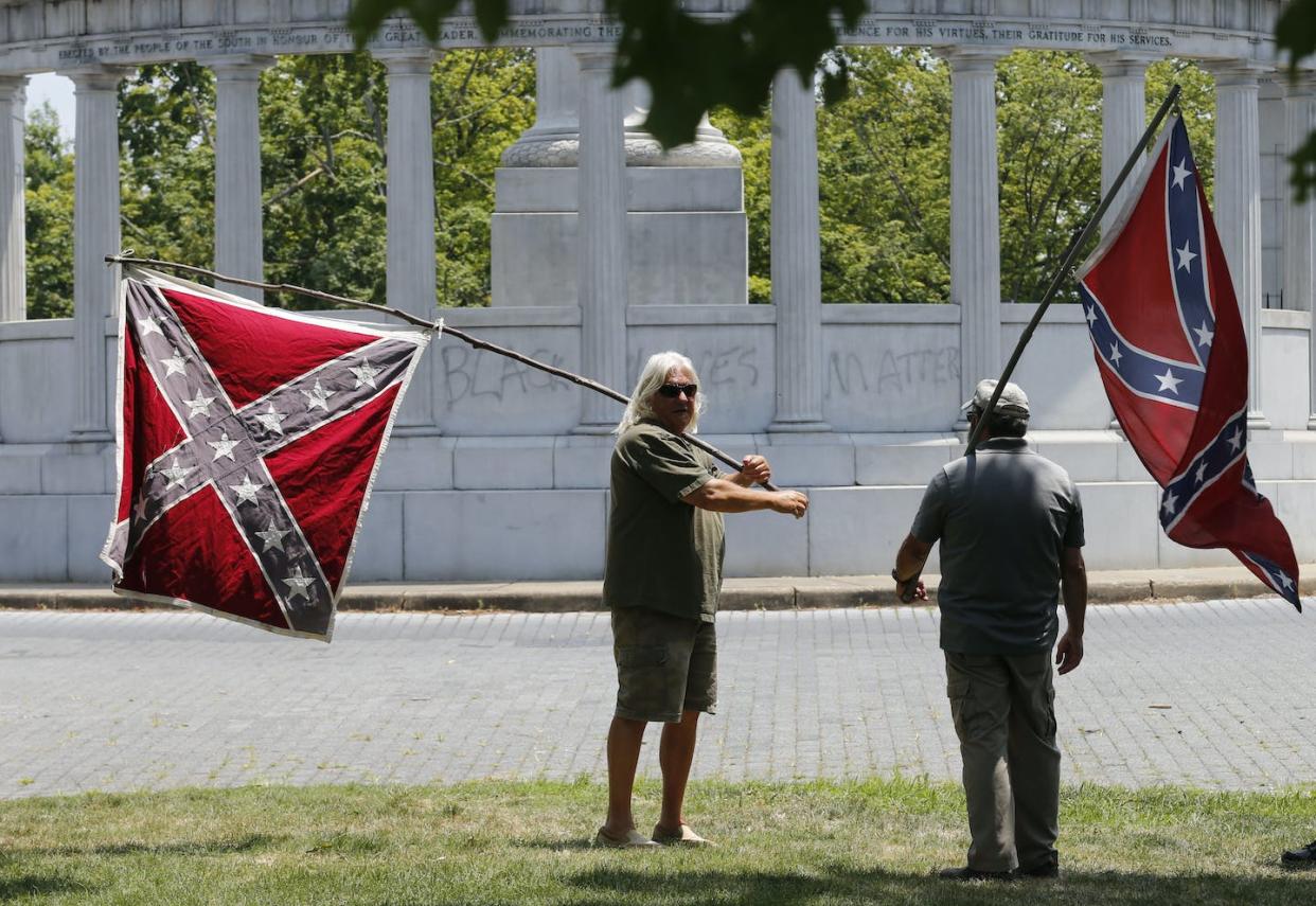 Demonstrators hold Confederate flags near the monument for Confederacy President Jefferson Davis on June 25, 2015, in Richmond, Va., after it was spray-painted with the phrase 'Black Lives Matter.' <a href="https://newsroom.ap.org/detail/DavisStatueVandalized/ebf030ed819f4497a47fa322218756f4/photo?Query=Confederate%20monuments&mediaType=photo&sortBy=arrivaldatetime:asc&dateRange=Anytime&totalCount=1935&currentItemNo=139" rel="nofollow noopener" target="_blank" data-ylk="slk:AP Photo/Steve Helber;elm:context_link;itc:0;sec:content-canvas" class="link ">AP Photo/Steve Helber</a>