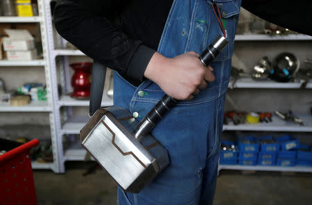 Geng Shuai, dubbed "Useless Edison" by his fans, carries a stainless steel handbag in the shape of a hammer as he gives a live broadcast at his workshop in Yangcun village of Baoding, Hebei province, China January 22, 2019. REUTERS/Jason Lee