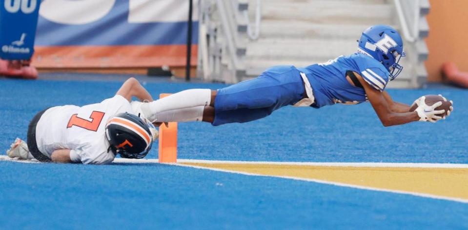 Emmett linebacker Kenyon Carter fights off a tackle by Fruitland’s Austin Tesnohlidek and dives across the goal line to finish a pick-six interception Friday to end the Huskies’ 27-14 win during the the Battle in Boise at Albertsons Stadium.